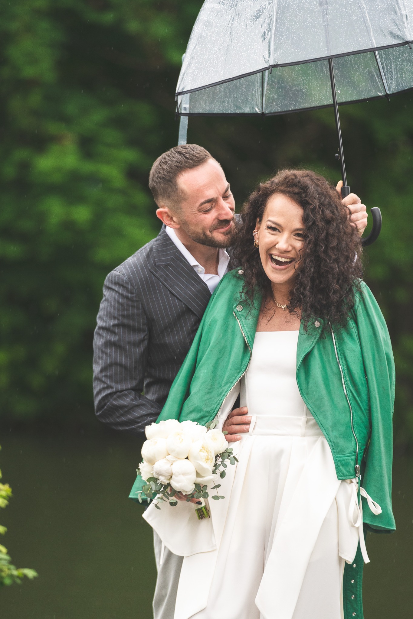 Couple laughing together beneath an umbrella