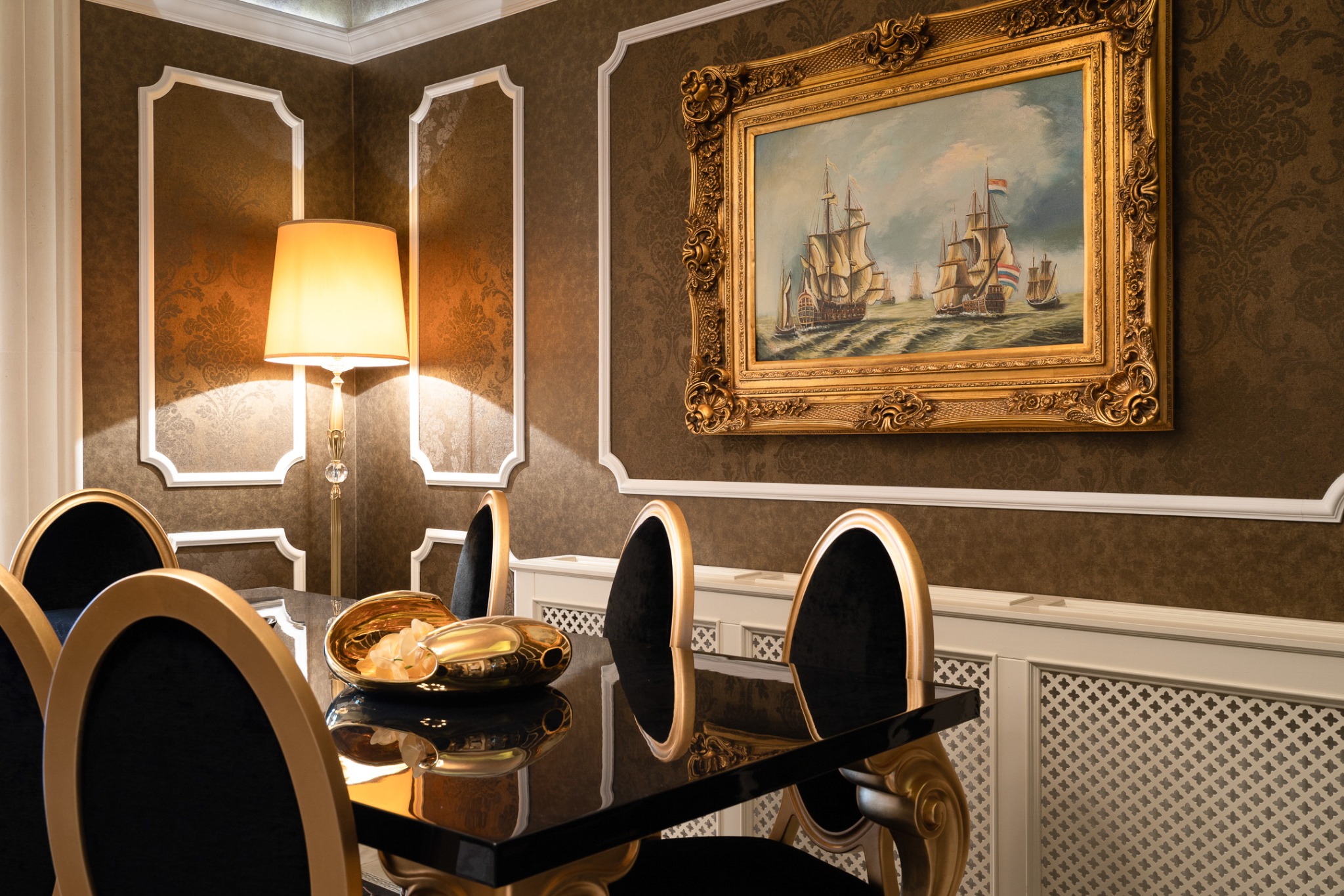 Dining table and upholstered chairs beneath a framed painting