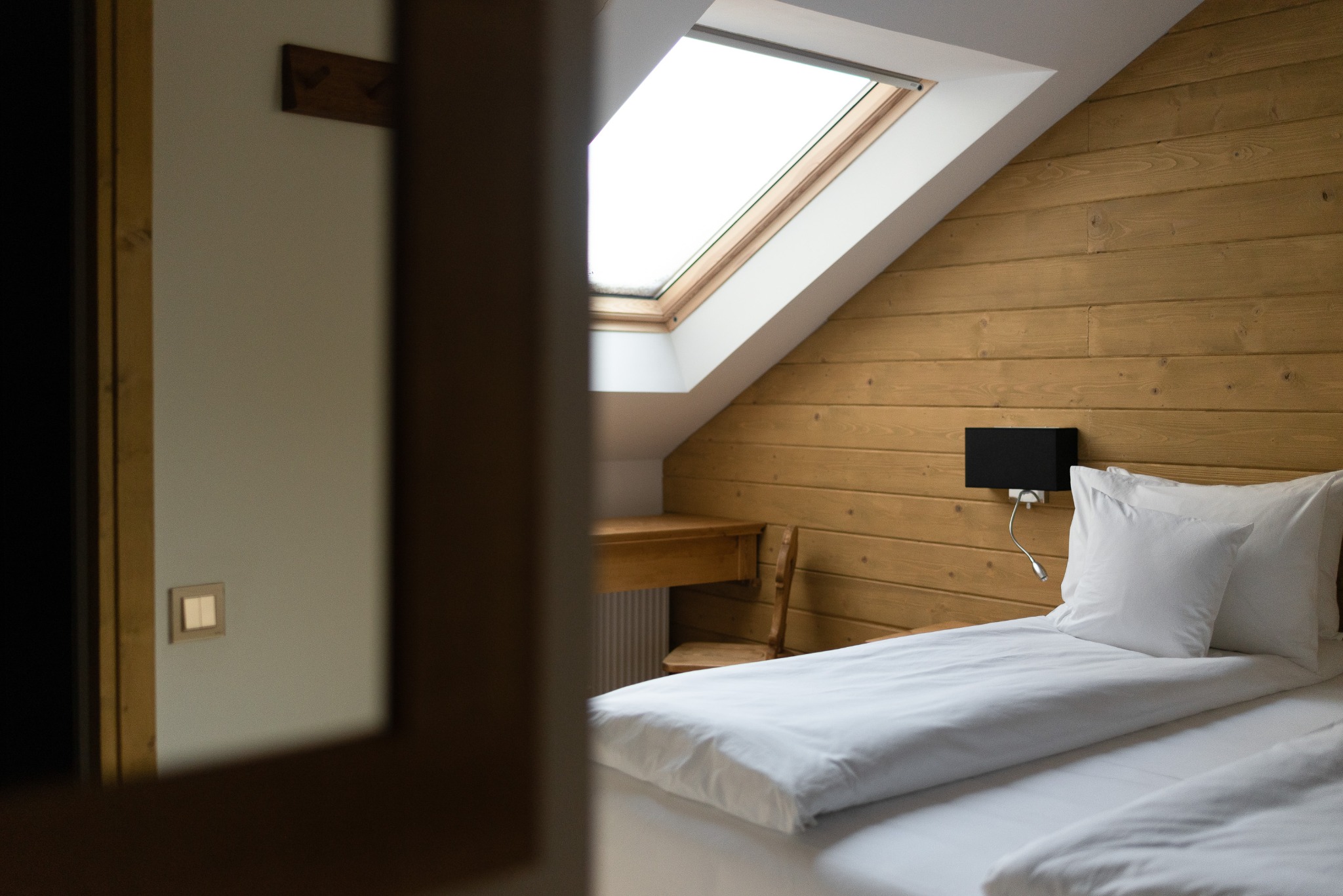 View through a doorway into a wood-paneled bedroom
